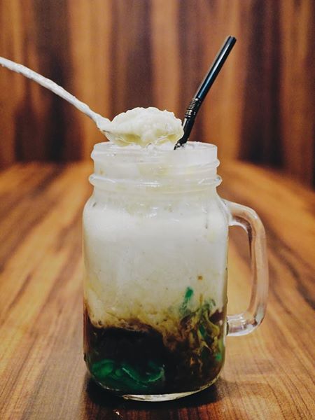 A creamy layered durian chendol milkshake in a glass mason jar made with Dessert Guru's ready-to-eat green pandan chendol.